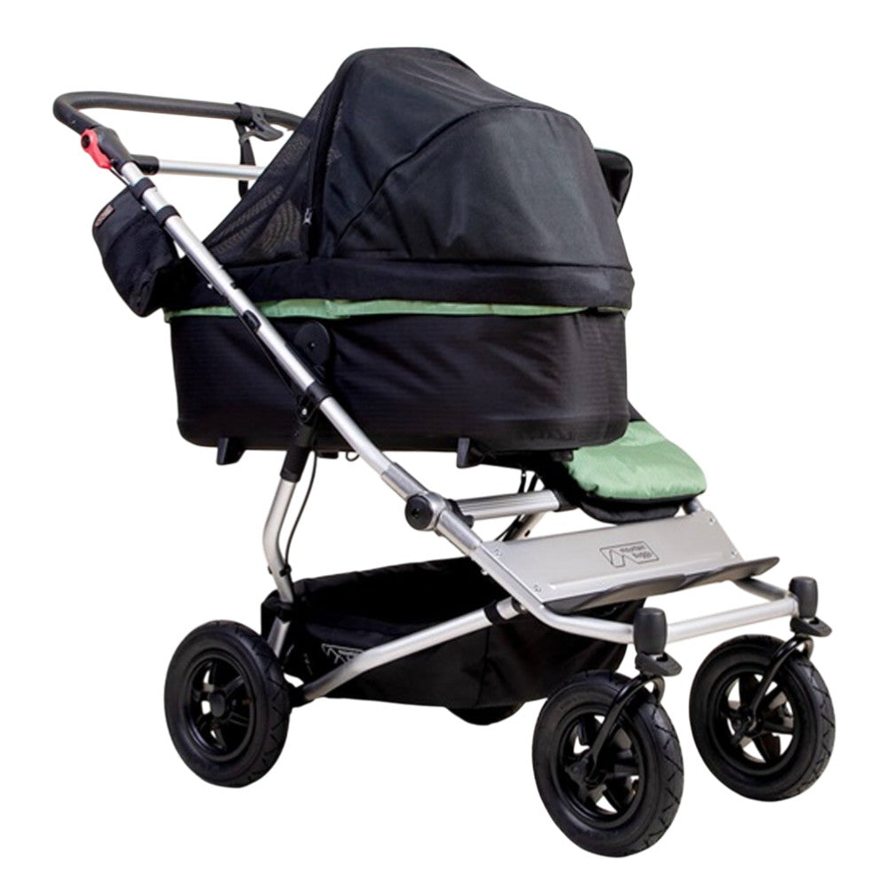 The Mountain Buggy Carrycot Plus Sun UV Mesh & Blackout Cover Set for V4 Duet, shown from the side against a white background, features a mesh cover for airflow and sun protection. Brand: Mountain Buggy.