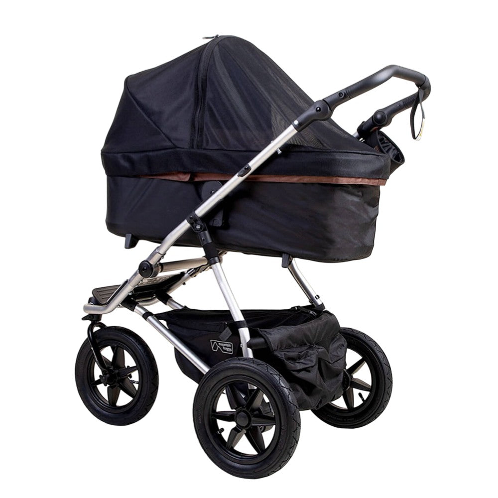 The Mountain Buggy Carrycot Plus Sun UV Mesh & Blackout Cover Set for V4 Urban Jungle and Terrain features a black covered bassinet, large all-terrain wheels, sturdy metal frame, and sun protection, shown side view on white background.