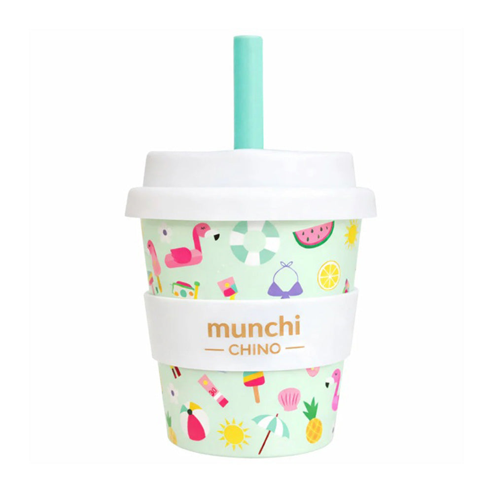 The Munchi 4oz Babychino Cup by Munchi features a turquoise silicone straw, white lid, and "munchi CHINO" band, with fun summer designs like flamingos, ice cream, and watermelons—perfect for kids’ drinks.