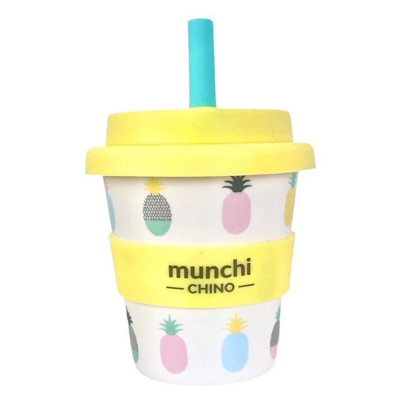 The Munchi Chino Babychino Cup with Straw by Munchi features a yellow lid, blue silicon straw, yellow “munchi CHINO” grip, and pastel pineapples on a white background—part of our babychino cups collection.