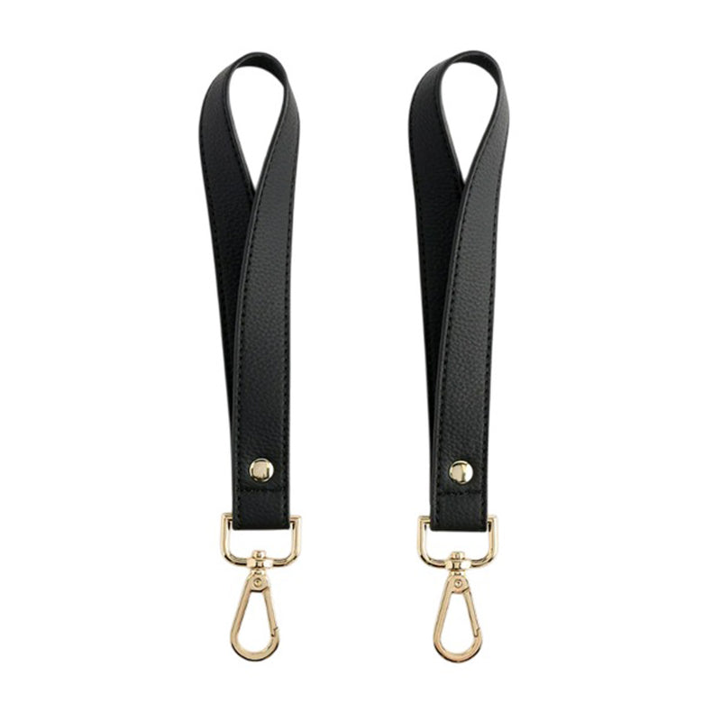 Neuwborne Milana Pram Straps by Neuwborne: a pair of black vegan leather straps with gold-tone clasps and rivets, displayed side by side on a white background. A stylish stroller accessory.