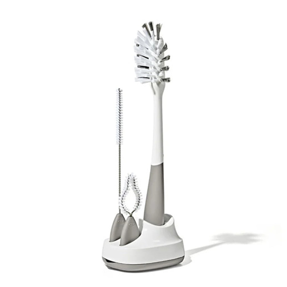 The OXO Tot Bottle & Straw Cup Cleaning Set features three bottle brushes in various sizes, including a straw cleaning brush, all in a matching white and gray holder—ideal for bottles and narrow containers.