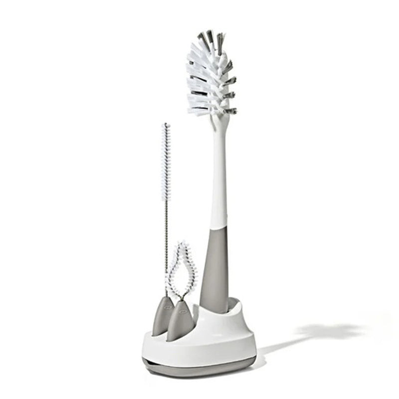 The OXO Tot Bottle & Straw Cup Cleaning Set features three bottle brushes in various sizes, including a straw cleaning brush, all in a matching white and gray holder—ideal for bottles and narrow containers.