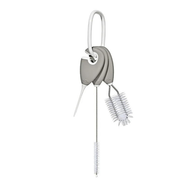 The OXO Tot Straw & Sippy Cup Top Cleaning Set includes three gray-handled brushes on a white ring, each designed to clean bottles, straws, and breast pump parts with ease.