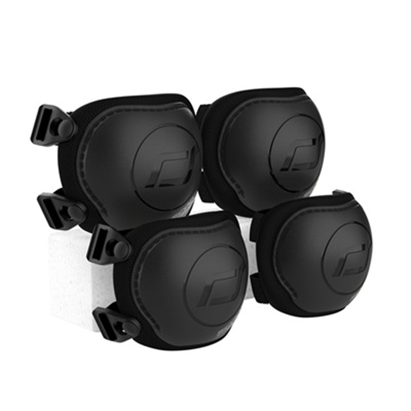The Scoot and Ride Protective Knee and Elbow Pack (XXS) by Scoot and Ride features four black pads with adjustable straps, arranged in pairs on a white block—designed for skateboarding, cycling, or similar activities.