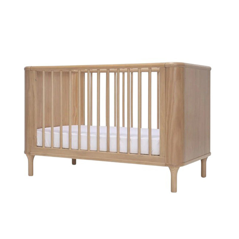 The Seena Willow Cot + Duo Dreamer Mattress Bundle by Seena features a wooden convertible cot with vertical slats, rounded corners, four short legs, and a white mattress, all crafted from sustainably sourced materials.