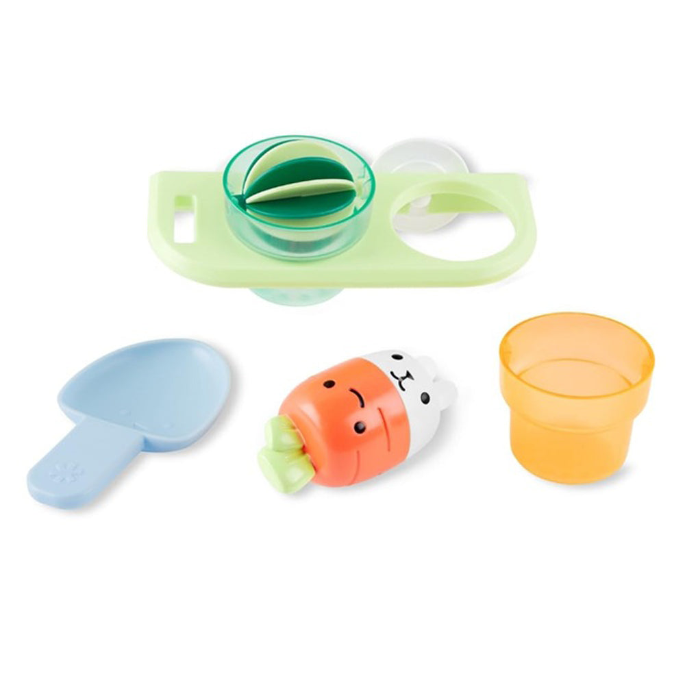 The Skip Hop Tub to Table Cafe Plant & Splash Set features a blue scoop, orange cup, green tray with compartments, and a carrot-shaped toy—perfect for toddler bath time fun and pretend play.