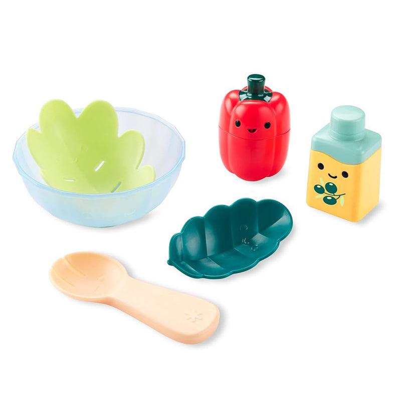 The Skip Hop Tub to Table Cafe Prep & Serve Salad by Skip Hop is a fun pretend-play bath toy set featuring a clear bowl, lettuce pieces, red pepper, yellow salad dressing bottle with smiles, green leaf, and beige spoon—perfect for tub time fun.