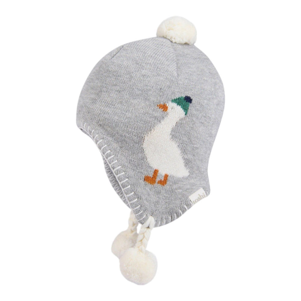 The Toshi Organic Earmuff Mystical Lucie Goosie by Toshi is a gray knit winter hat with ear flaps, white pom-poms, and a playful white duck in a green hat design, crafted for warmth and comfort.