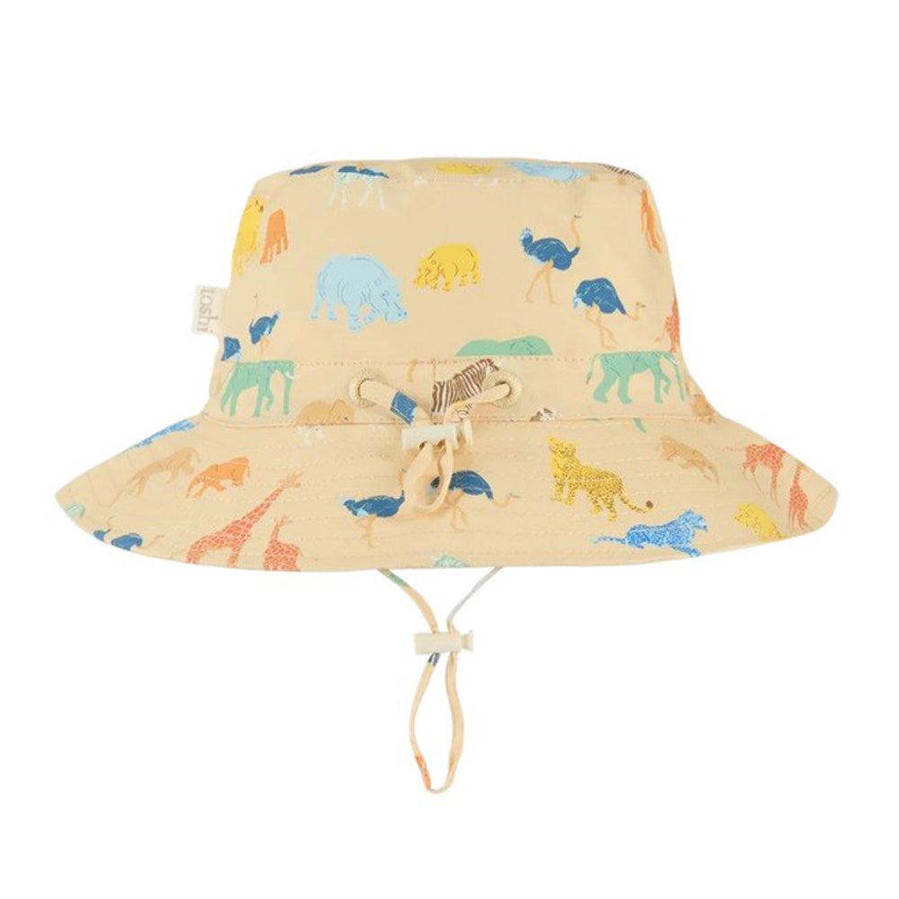 The Toshi Sunhat Banjo Congo Driftwood is a beige cotton bucket hat featuring colorful animal prints, UPF 50+ protection, and an adjustable chin strap and toggle—perfect sun protection for kids on sunny days.