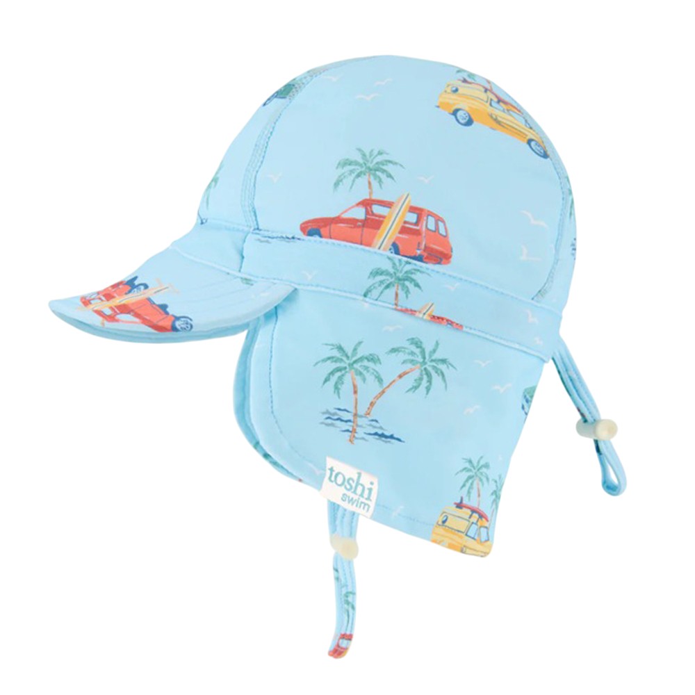 The Toshi Swim Flap Cap Paradise Swell Seekers Sky is a light blue baby swim hat with neck flap and chin strap, decorated with palm trees, birds, and cars. It offers UPF50+ sun protection and features the Toshi brand name on the front.