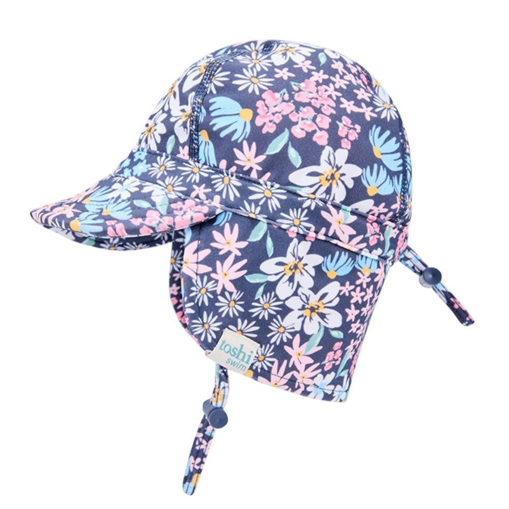 The Toshi Swim Flap Cap Paradise Wattle Dusk is a navy children’s cap with floral print, UPF50+ sun protection, brim, neck flap, chin strap, and adjustable drawstrings—ideal for pairing with Toshi baby swimwear.
