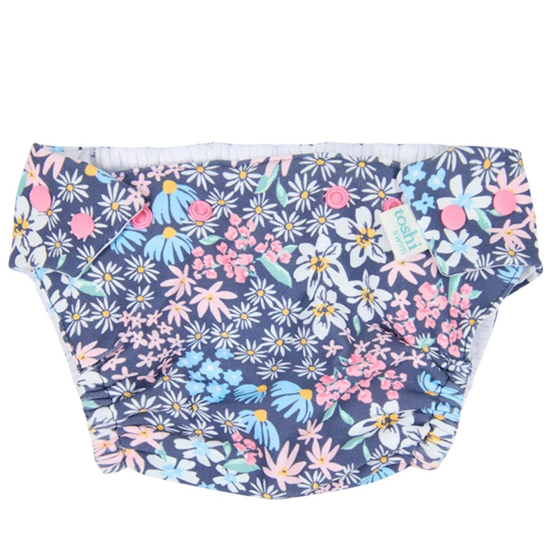 The Toshi Swim Nappy Paradise Wattle Dusk features a reusable design with a vibrant floral print on a dark blue background, making it the perfect stylish swimwear choice for your baby.
