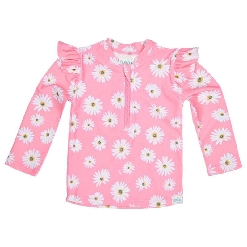 The Toshi Swim Rashie L/S Ripple Daisy Watermelon features long sleeves, white daisy prints, ruffled shoulders, a front zipper, and UPF50+—perfect children's swimwear or for pairing with other Toshi pieces on sunny days.