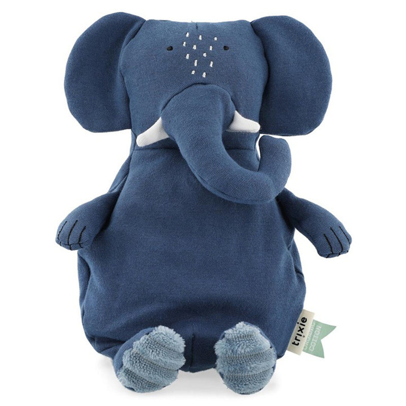 The Trixie Plush Toy Small Mrs Elephant by Trixie is a cozy blue elephant made from organic cotton, featuring large floppy ears, a long trunk, small white tusks, embroidered details, and a green eco-friendly tag.