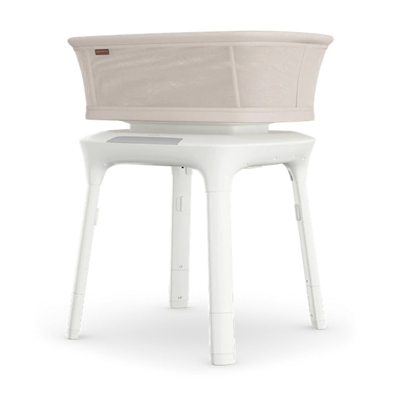 The UPPAbaby SOMA Smart Bassinet by UPPAbaby features a modern cylindrical white design with mesh sides, four sturdy legs, and advanced baby sleep technology for a contemporary nursery.
