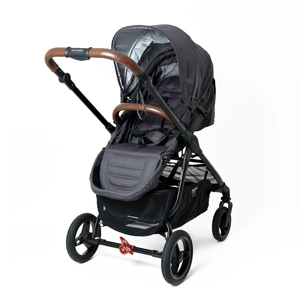 The Valco Baby Trend Ultra Elite by Valco Baby is a modern black lightweight stroller with brown handles, padded seat, canopy, storage basket underneath, and an easy one-hand folding system, shown on a white background.