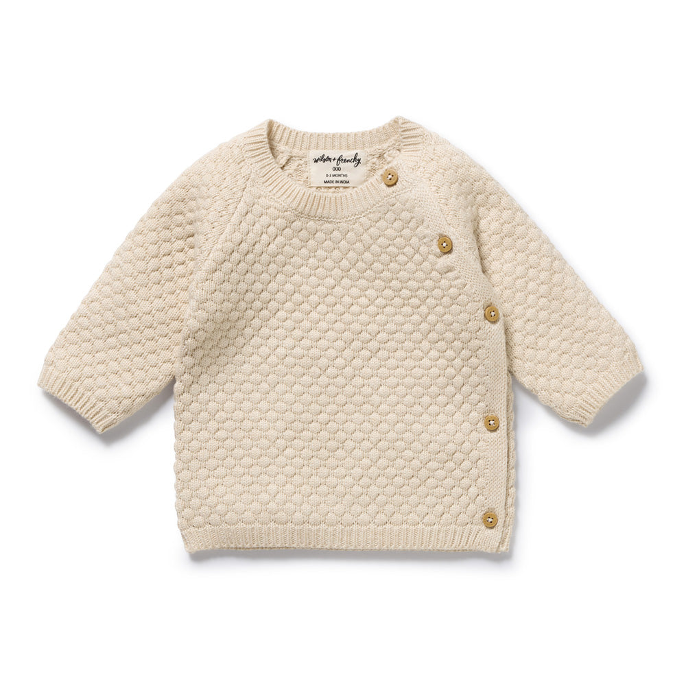 The Wilson & Frenchy Cream Organic Knitted Bubble Kimono Cardigan features textured knit, long sleeves, and four brown buttons along the left shoulder and side. It is displayed flat on a white background.