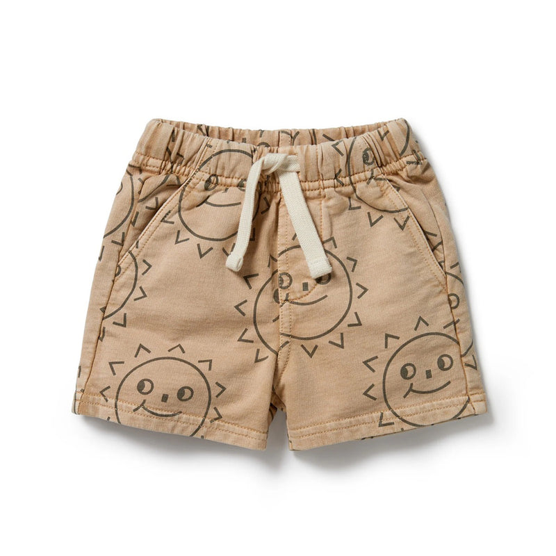 The Wilson & Frenchy Happy Days Organic Sweat Long Short features a tan color, white drawstring, and smiling sun face print. Made from GOTS-certified organic cotton French terry, these toddler shorts offer softness and style for sunny days.