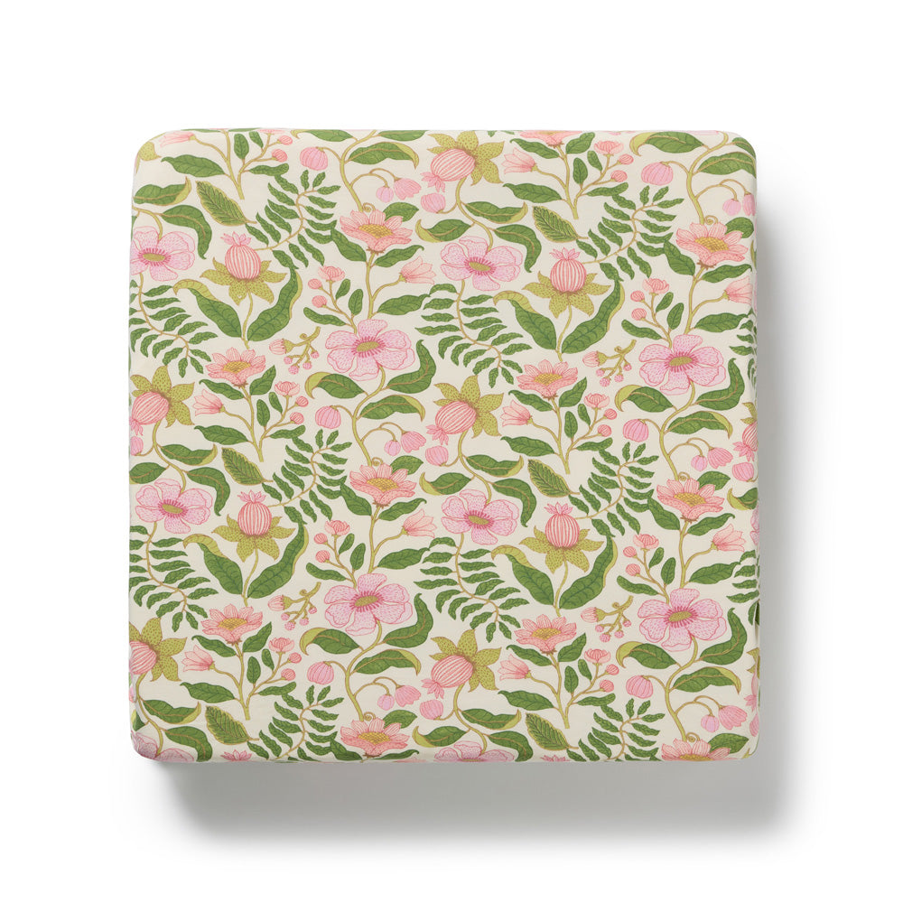 The Wilson & Frenchy Ma Fleur Organic Sheet by Wilson & Frenchy features pink flowers and green leaves on a cream background—an ideal match for any bassinet sheet or organic cotton fitted sheet.
