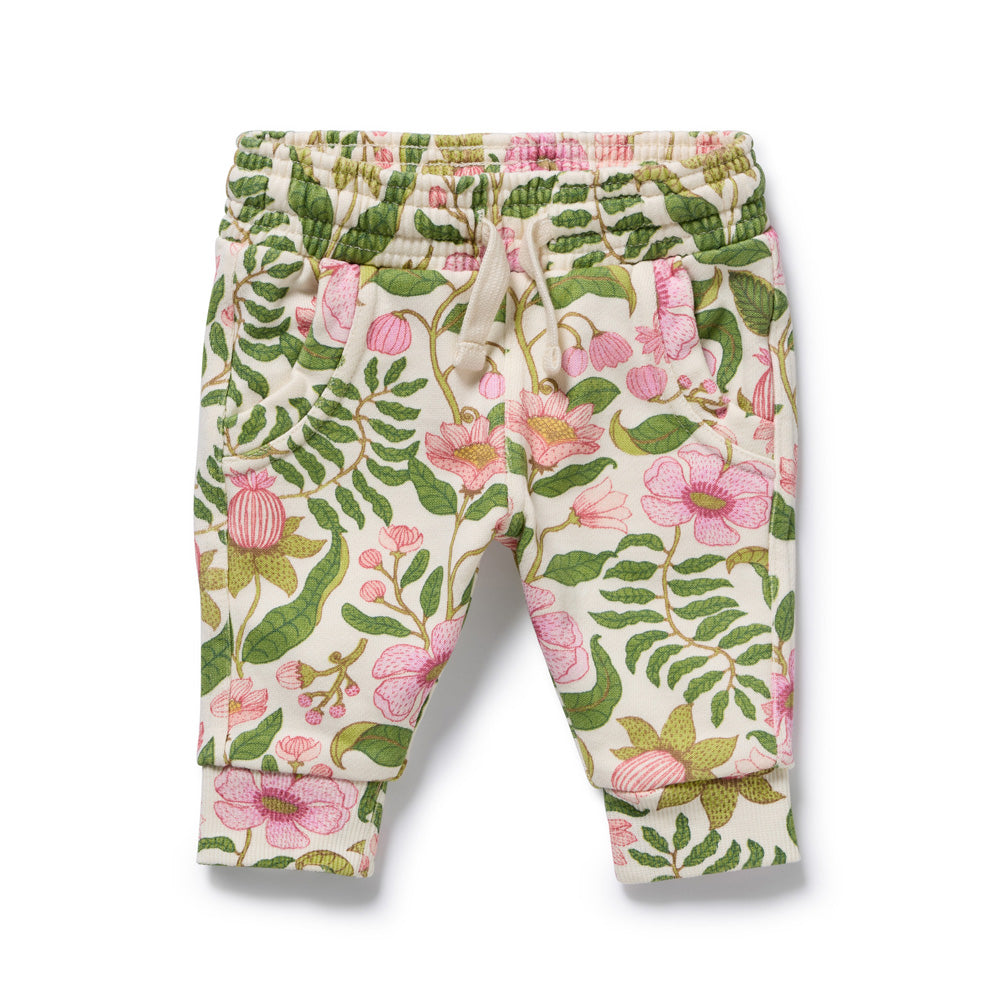 Wilson & Frenchy Ma Fleur Organic Terry Sweat Pant by Wilson & Frenchy features GOTS-certified organic cotton, an elastic waistband with drawstring, two front pockets, cuffed ankles, and a cream floral print with green leaves and pink flowers.