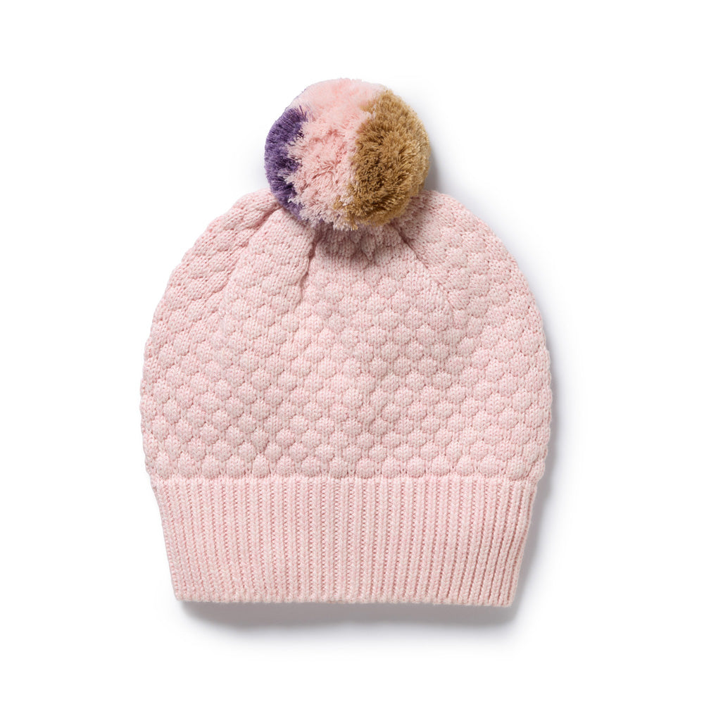 The Wilson & Frenchy Marshmellow Organic Knitted Bubble Hat features a light pink bubble knit design and a large multicolored pom-pom in pink, purple, and brown—a cute winter accessory for chilly days.