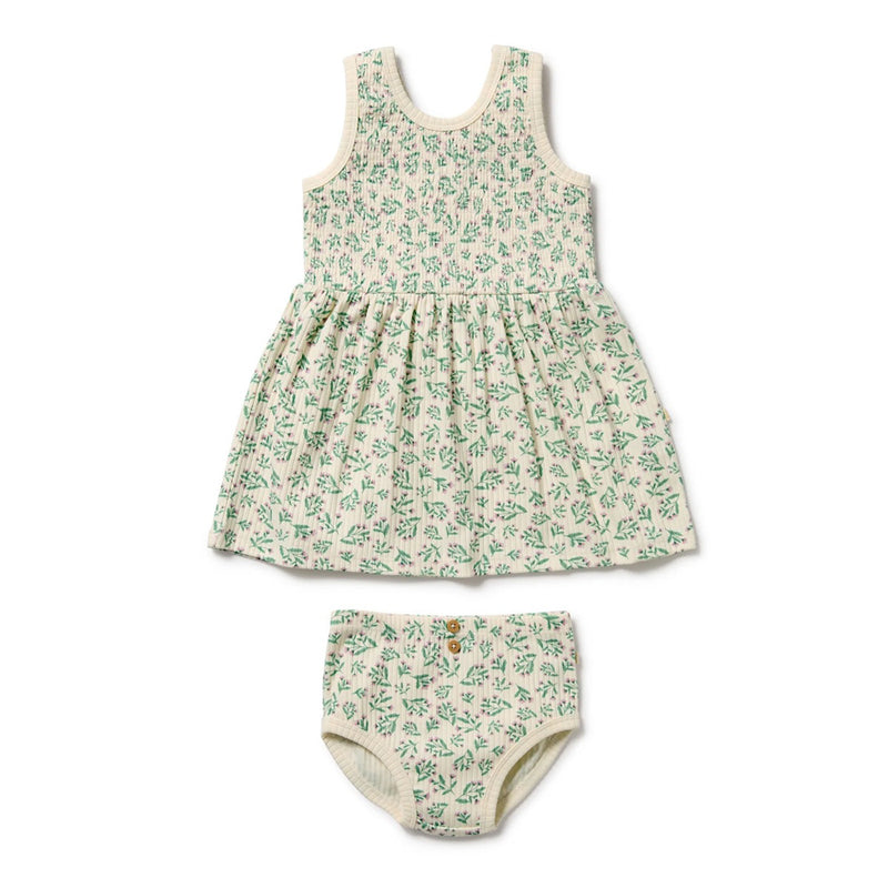 The Wilson & Frenchy Periwinkle Organic Dress Set is a sleeveless, cream-colored baby dress with a green floral pattern and matching bloomers—a GOTS-certified, adorable choice from Wilson & Frenchy.