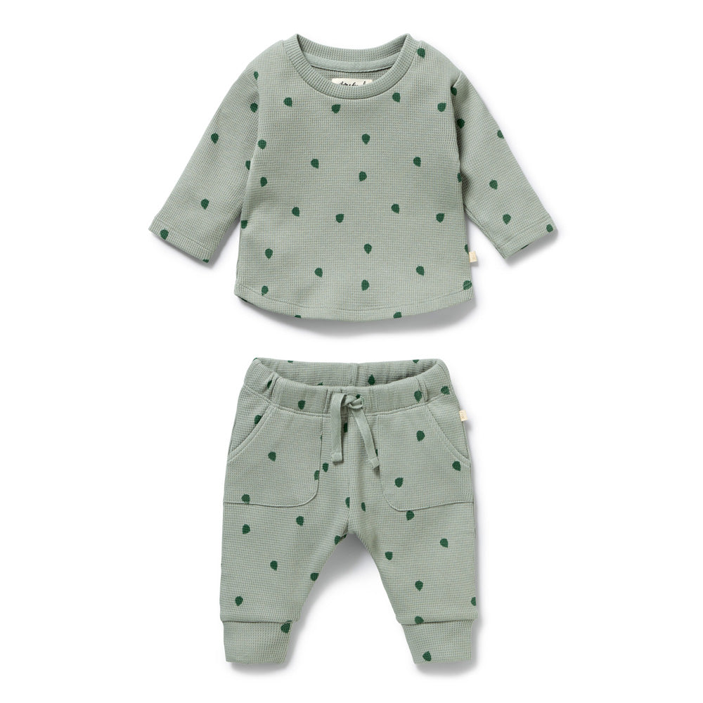The Wilson & Frenchy Tumbletwig Organic Waffle Set is a two-piece baby outfit in light green with dark green polka dots, front pockets, and a drawstring waist. Made from soft organic cotton and GOTS certified for peace of mind.