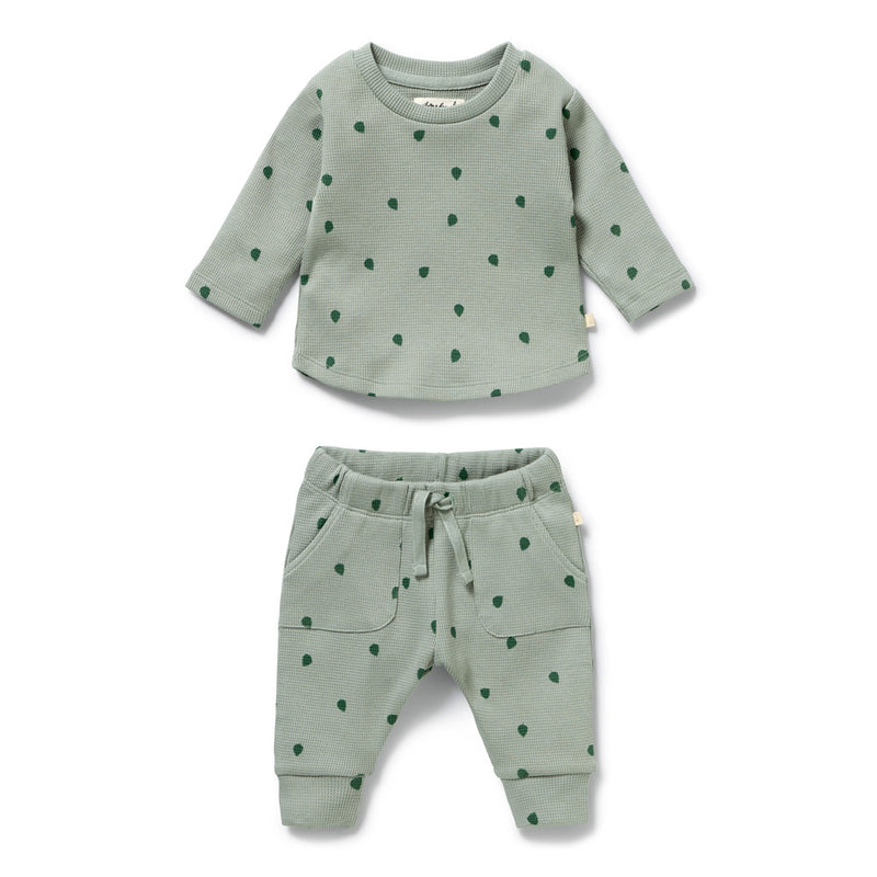 The Wilson & Frenchy Tumbletwig Organic Waffle Set is a two-piece baby outfit in light green with dark green polka dots, front pockets, and a drawstring waist. Made from soft organic cotton and GOTS certified for peace of mind.