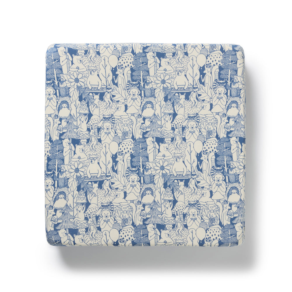 The Wilson & Frenchy Woodland Adventures Organic Sheet features a charming blue and white pattern with playful cartoon animals, plants, and whimsical shapes—perfect to pair with your baby crib or fitted sheet. Shown on a white background.