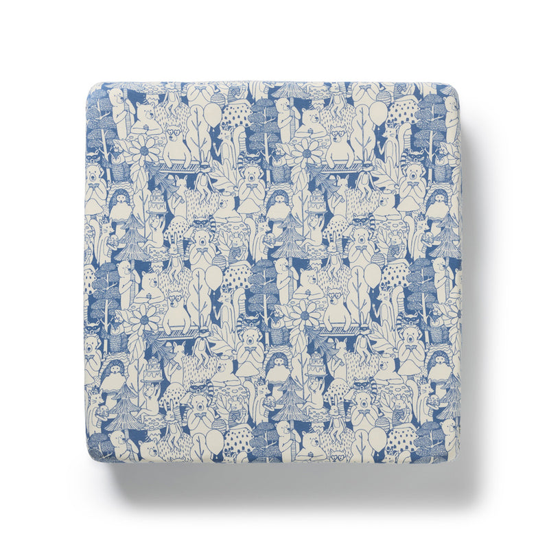 The Wilson & Frenchy Woodland Adventures Organic Sheet features a charming blue and white pattern with playful cartoon animals, plants, and whimsical shapes—perfect to pair with your baby crib or fitted sheet. Shown on a white background.