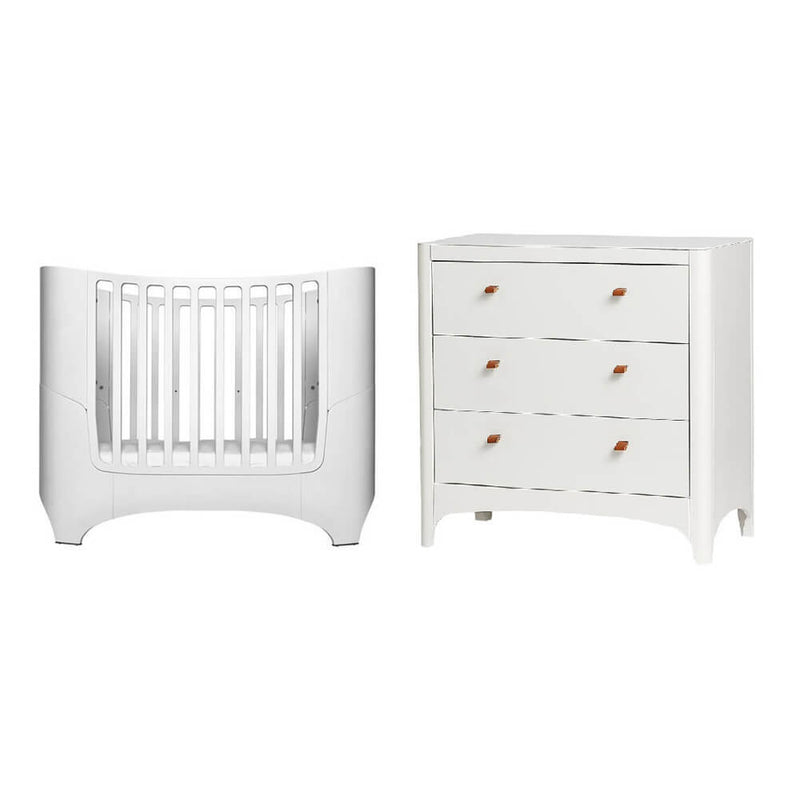The Leander Classic Cot, paired with the Leander dresser and mattress, features vertical slats and brown leather pull handles for a modern Scandinavian look.