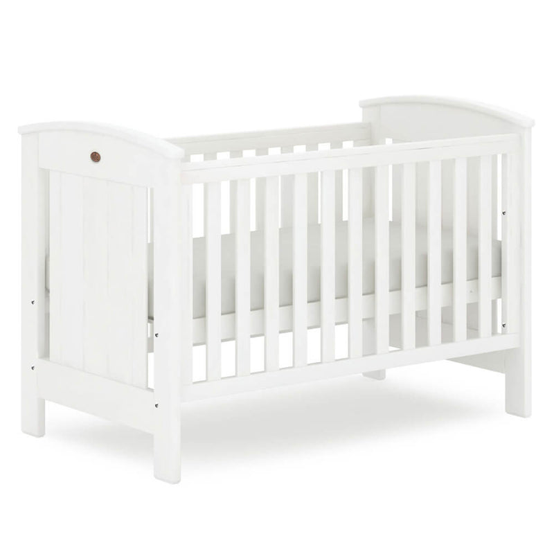 The Boori Casa Cot by Boori is a white wooden convertible cot bed with slatted sides, a solid headboard and footboard, showcasing a simple, classic design. The crib is empty and set against a plain white background.