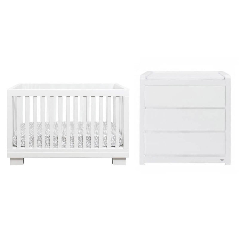 The Cocoon Aston Cot + Change Table by Cocoon features a sleek white design with vertical slats and ample storage, creating a modern look ideal for fans of designer nursery furniture.