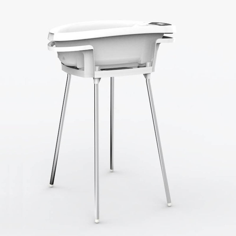 The Roger Armstrong Aquascale Baby Bath + Stand features a modern white baby bath with a digital display and built-in thermometer, securely placed on a tall four-legged metal stand, shown against a plain white background.