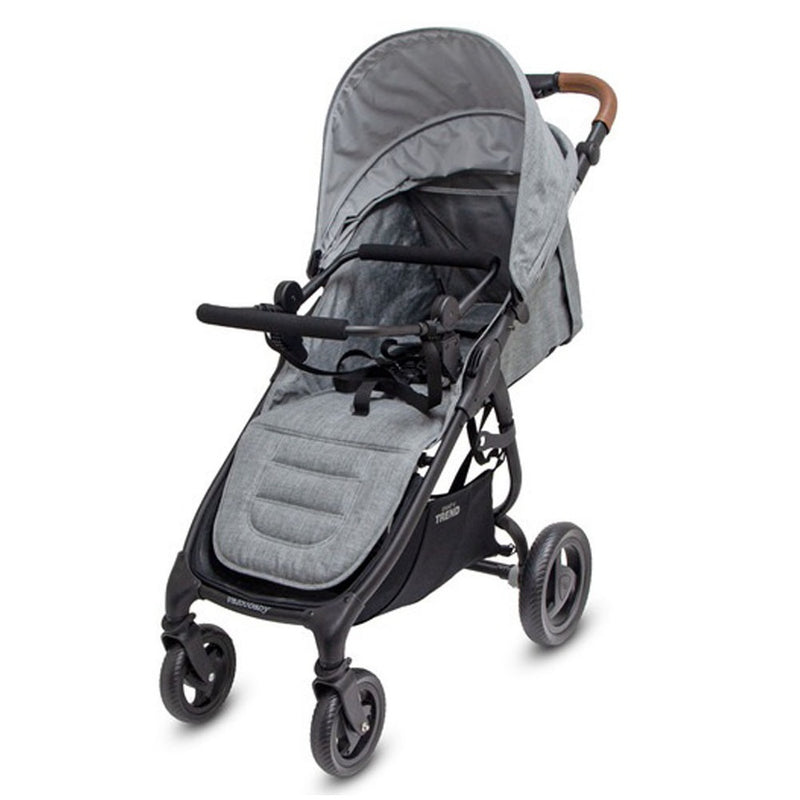 The Valco Baby Trend4 stroller in gray has a padded seat, canopy, four wheels, black frame with brown faux-leather handle, storage basket, and is compatible with the Valco Baby Universal Travel System Adapter for convenience.