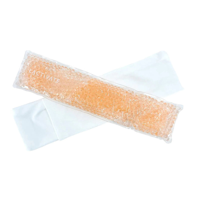 A rectangular Lactivate Perineal Ice Pack with peach-colored gel beads, designed for postpartum recovery, sits on a folded white cloth sleeve.