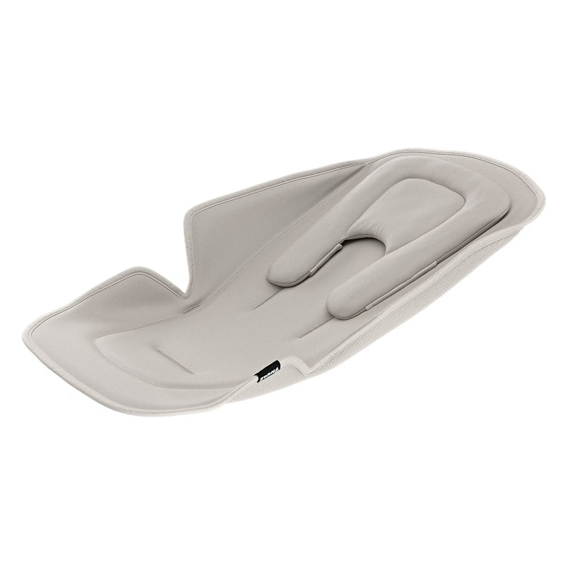 The Thule Newborn Inlay is a light gray, contoured insert with padded sides and head support, designed by Thule to fit lay-flat strollers or car seats for extra comfort and protection for newborns.