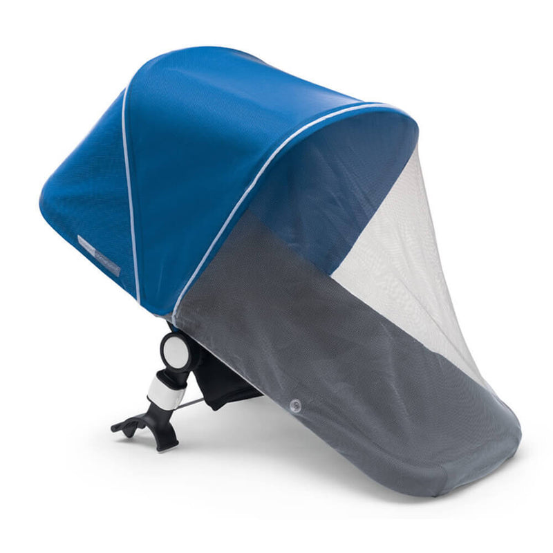 A Bugaboo Mosquito Net by Bugaboo is attached over a blue stroller canopy, protecting the child from sun and insects. The mesh cover, frame, and mounting mechanism are all visible at the base.