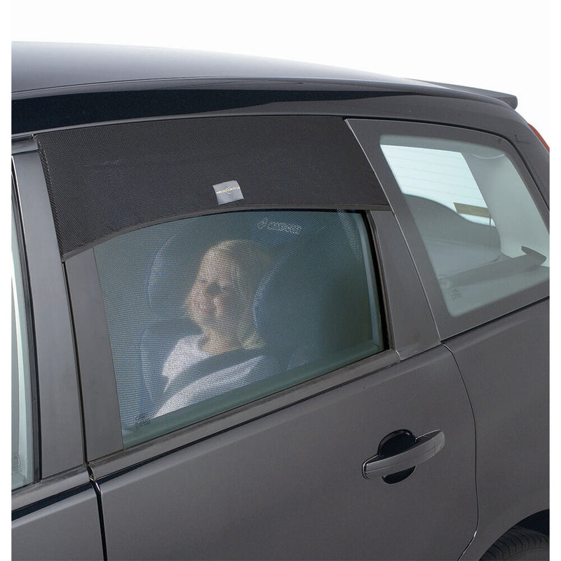 A young child sits in a car seat inside a vehicle, visible through a rear side window covered by an Outlook Auto Shade from Outlook for added UV protection.